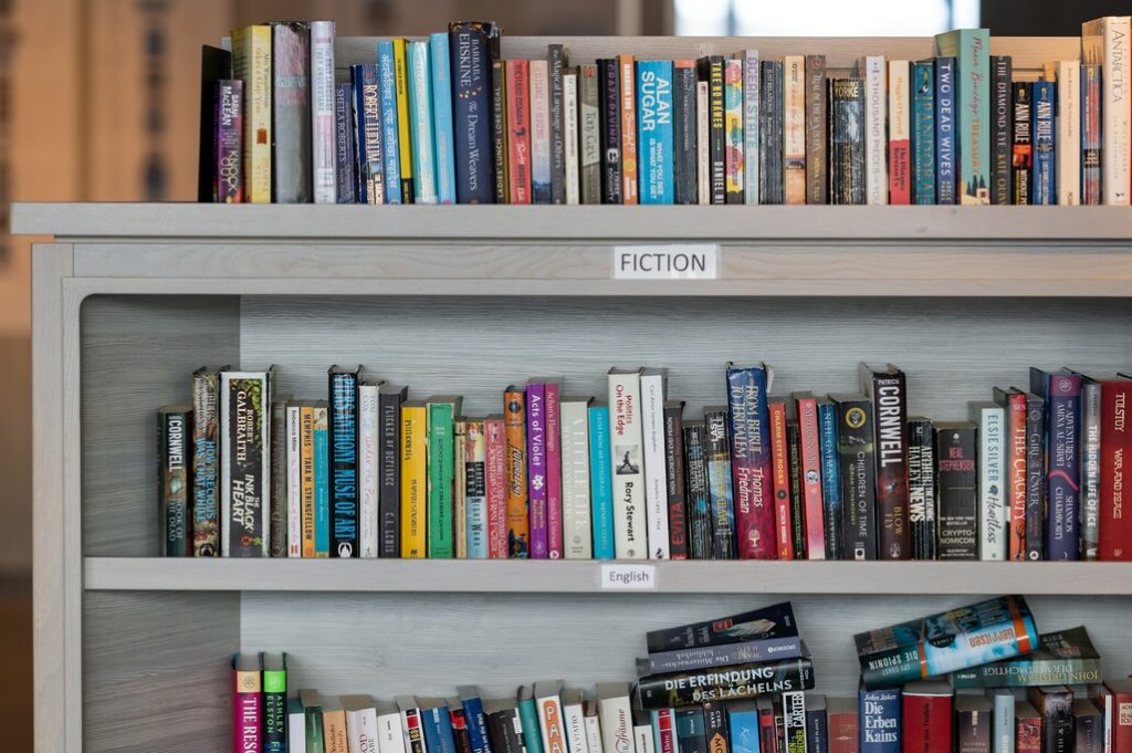 Ein Bücherregal mit mehreren Regalböden, das eine Vielzahl von Büchern enthält. Die abwechslungsreiche Sammlung ist Bestandteil des Science-Centers der MS Fridtjof Nansen.